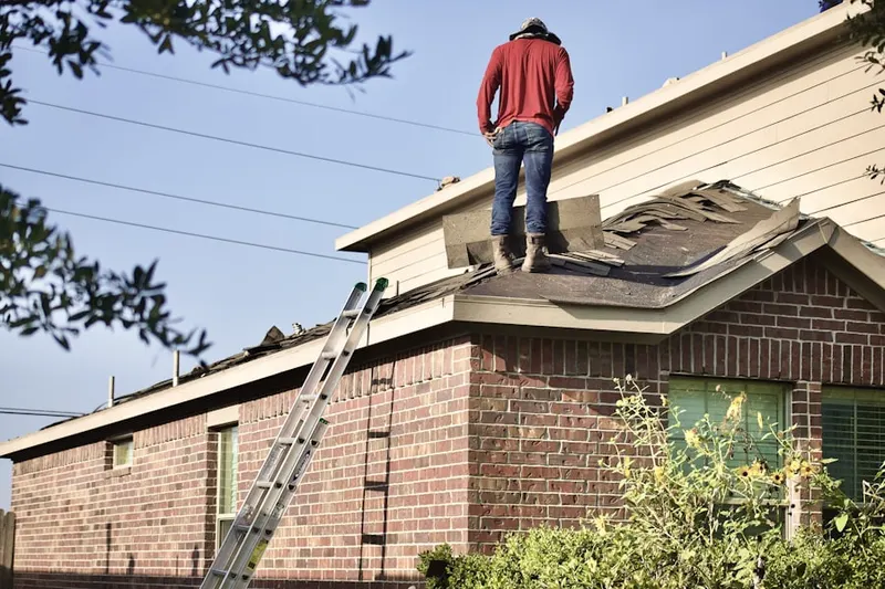 Professional roofer working on a residential roof in Alton Homes